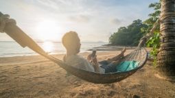 man in hammock using smartphone