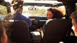 family in car on road trip